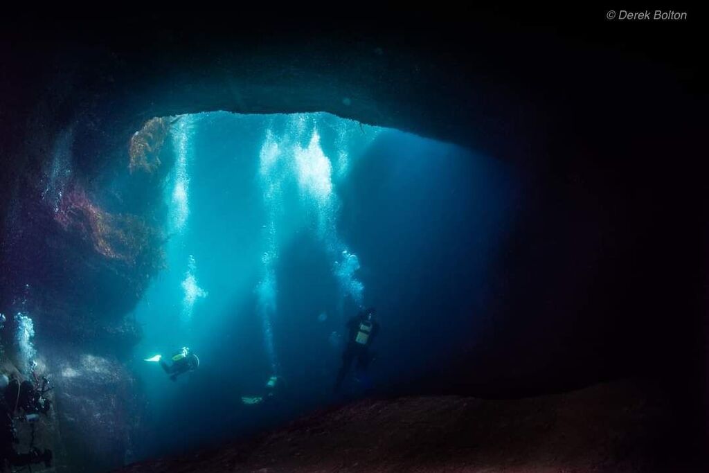 Group of advanced divers explore Wormhole underwater with dive aran